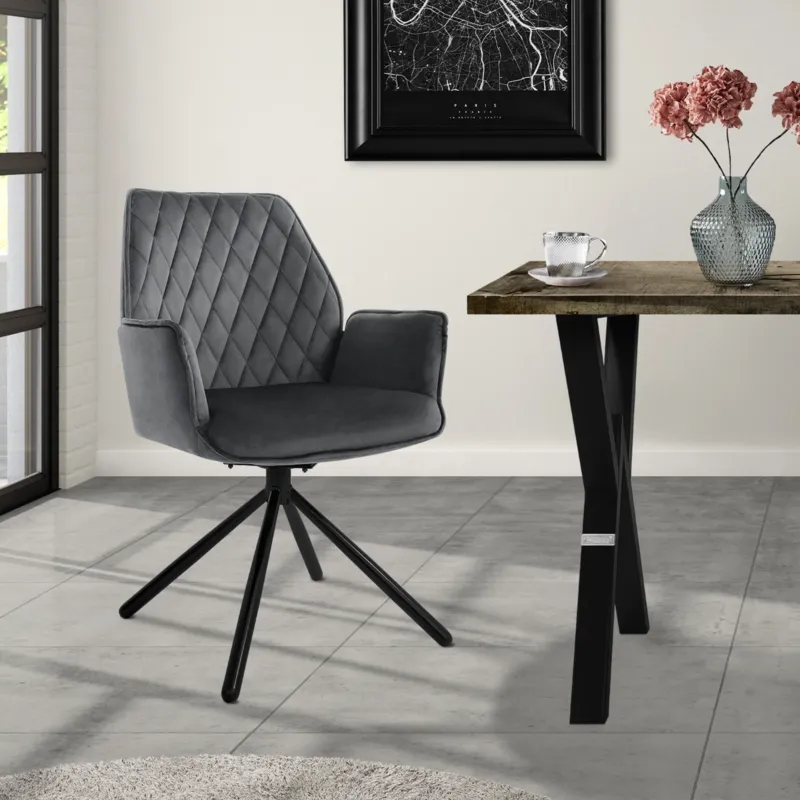 Grauer Stuhl mit Rautenmuster, Tisch und Blumen im Raum.