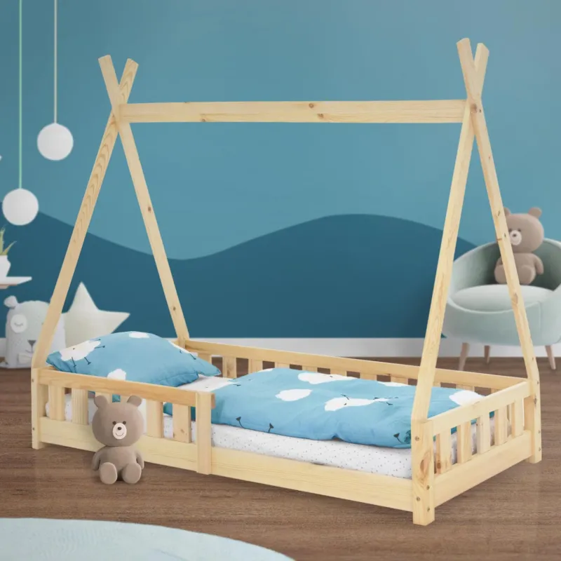Ein Bett im Zelt-Design mit blauen Bettwäsche und einem Teddybär.